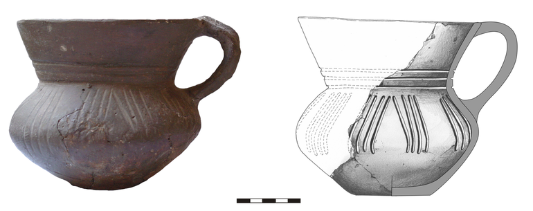 Dzban typu D21, zdobiony na szyjce trzema rytymi liniami poziomymi, na brzuścu – grupami lekko ukośnych linii rytych (po cztery), zwróconych góra ku sobie. Krawędź zaokrąglona, dno niewyodrębnione. Domieszka tłuczonego kamienia i krzemienia. H – 13,5  cm, R1 – 14,4  cm, R2 – 10  cm, R3 – 14,4  cm, R4 – 5,7  cm