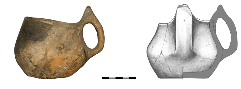 Kubek typu K22a, niezdobiony. Krawędź zaokrąglona, dno niewyodrębnione, ucho taśmowate typu ansa lunata. Domieszka tłuczonego kamienia i krzemienia. H – 11  cm (z uchem), 9 cm (bez ucha), R1 – 8,5  cm, R3 – 11,5  cm, R4 – 7,3  cm